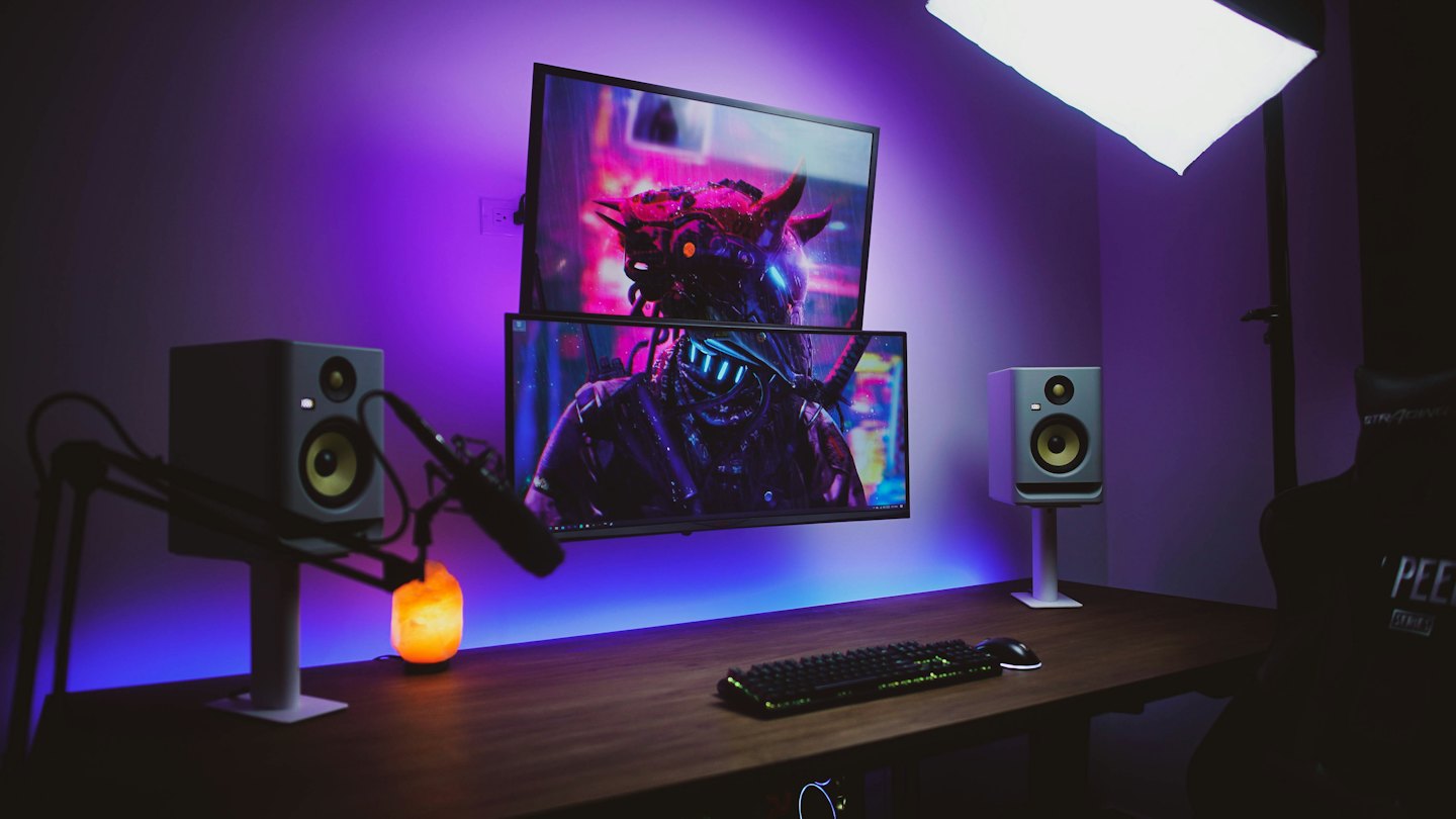 Ein Schreibtisch eines Streamers mit zwei Monitoren, die Cyberpunk-Kunst zeigen.